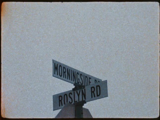 Two street signs are shown crossing over each other with sepia flashing briefly