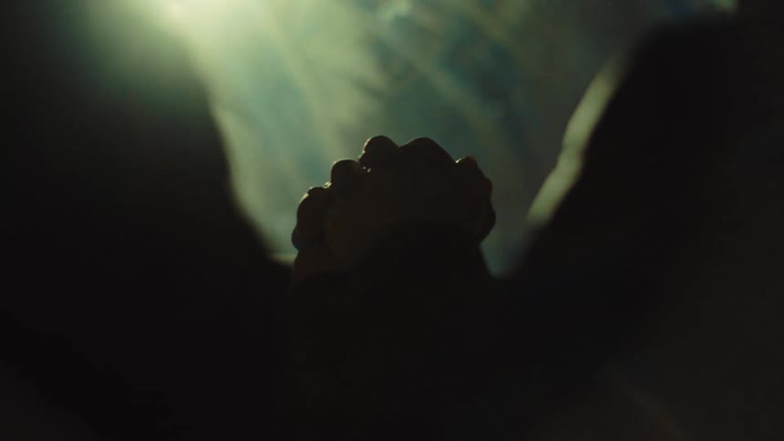 Hands joined by two people inside a moving car