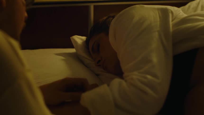 A man watches over his deeply sleeping wife