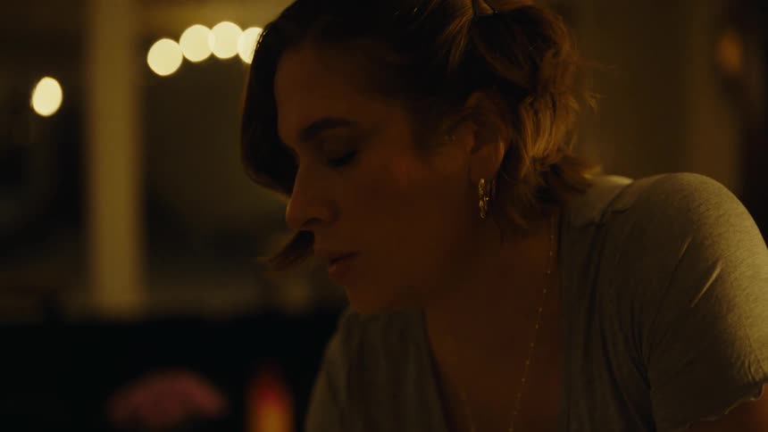 A woman leans forward in the room