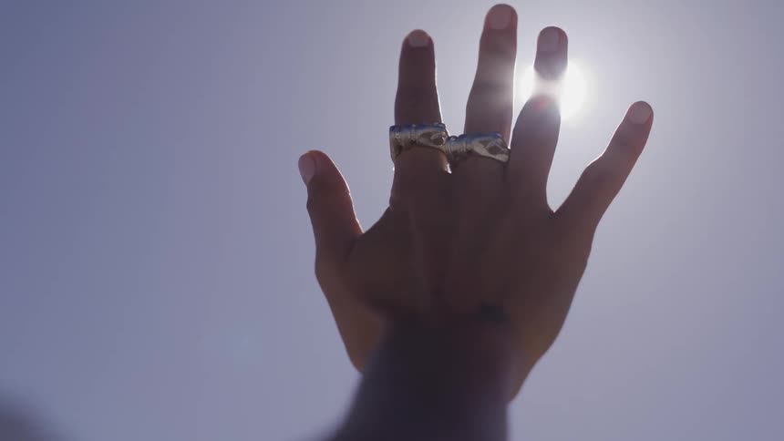 A hand blocks out the sun