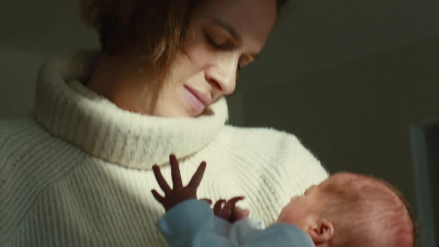 A mother gazing lovingly at her newborn baby