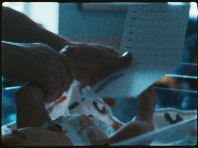 A closeup of a persons hands holding a piece of paper while they take a babys foot print on the paper