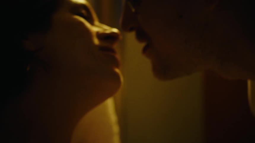 Man kissing a woman who is lying down
