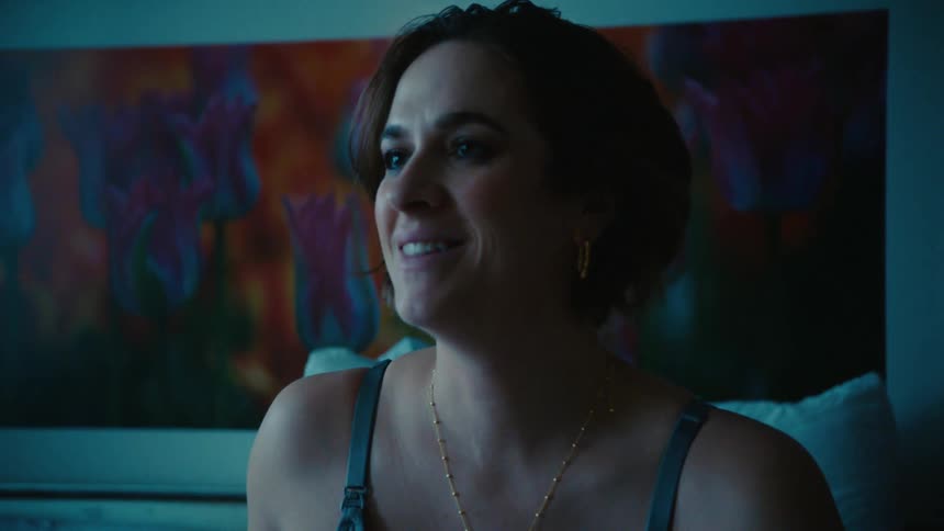 A woman smiles while sitting in bed