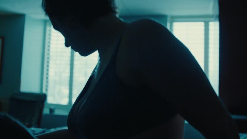 Pregnant woman walking slowly with help from a nurse