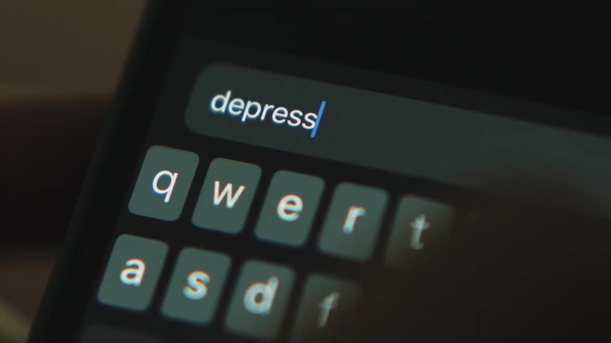 Person enters the word depression using phone keyboard