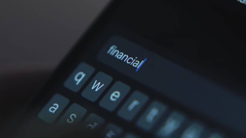 Letters glow on a small keyboard as someone types on an electronic device