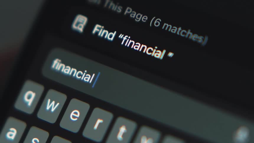 White letters are on a small keyboard as someone types financial crisis