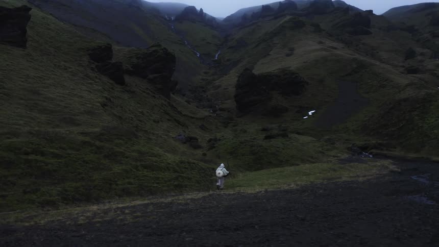 A person walks across a mountain path