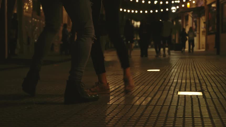 2 people dance while others walk around