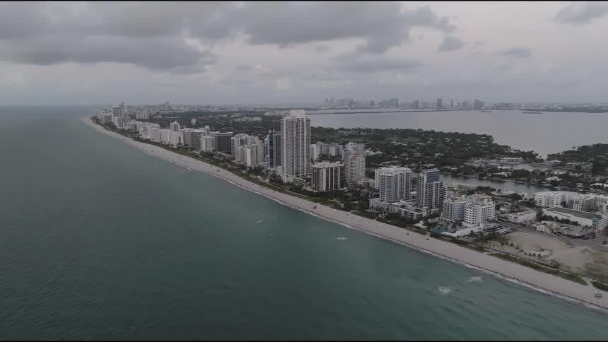 Dark clouds float over a large city and beach