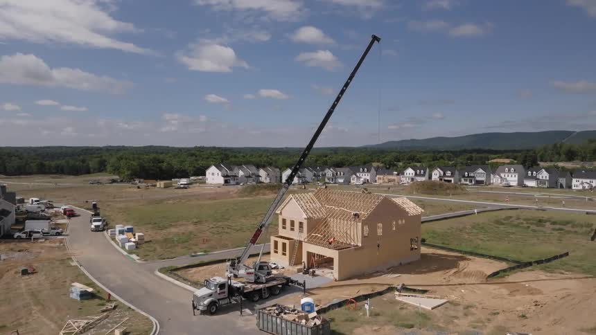 Aerial view of a twostory house under construction with machinery and workers