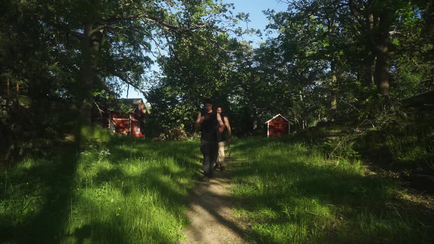 Two men walking along a trail with trees around them