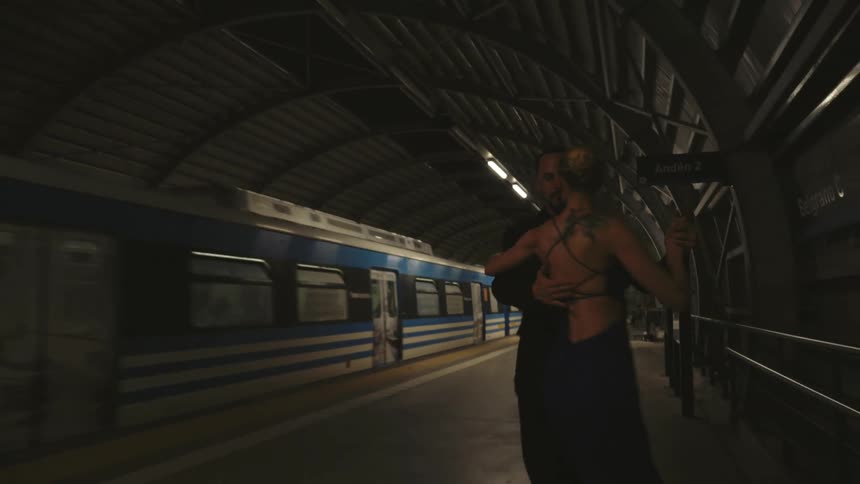 A couple dancing in a train station
