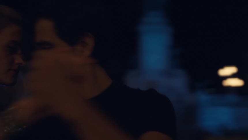 Couple dances on a downtown sidewalk at night