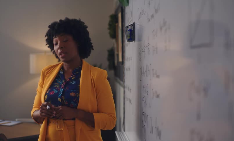 Female teacher with happy facial expression teaching in classroom
