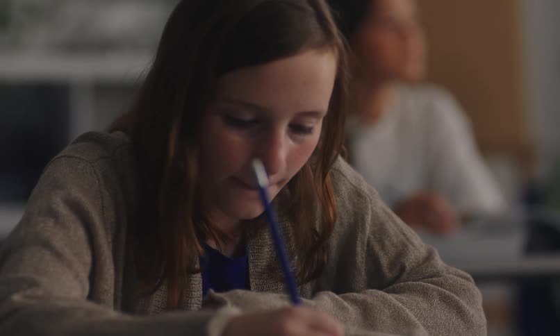 A girl writes during class