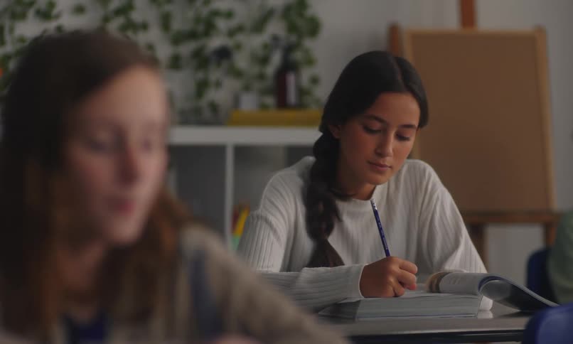 Students sitting in a classroom taking notes from class