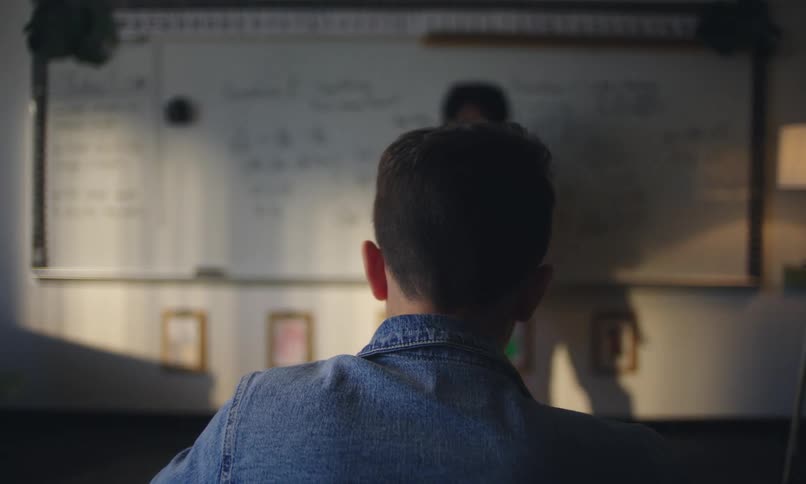 Male student listens while his teacher lectures