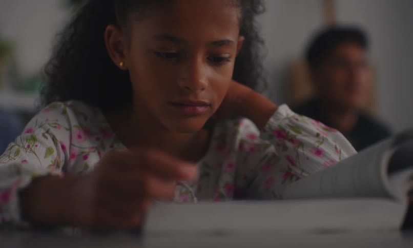 Portrait of a little girl sitting reading in the classroom