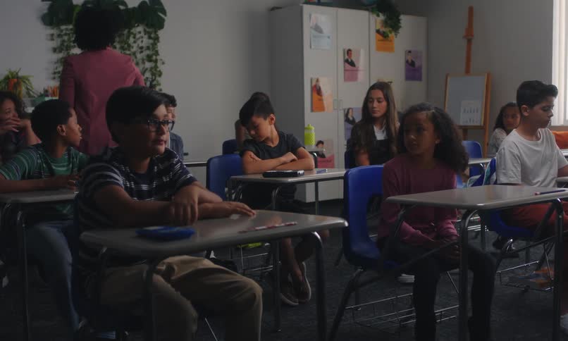 A teacher interacts with students in a classroom setting