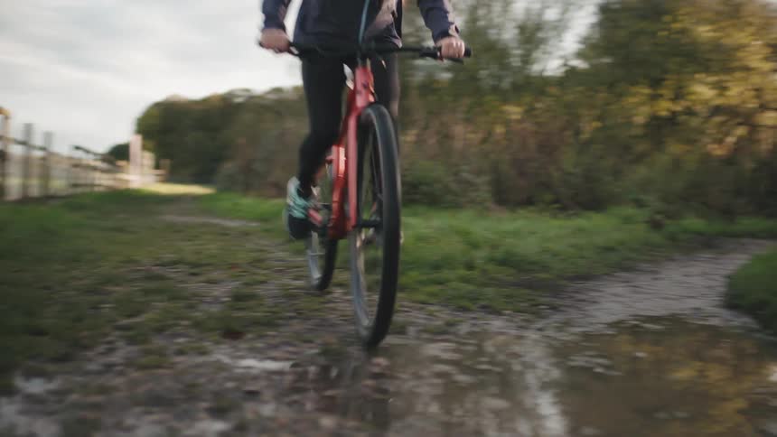 Man riding a bike on a trail made up of water and mud