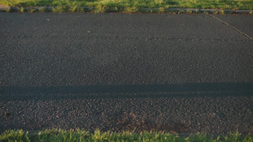 A child rides a bicycle over an asphalt path