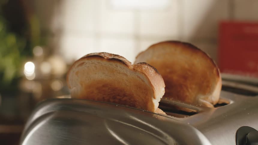 Toast popping up from metal toaster in the morning