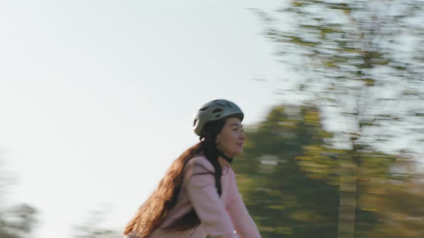 A person riding a red bicycle on a treelined path in a park