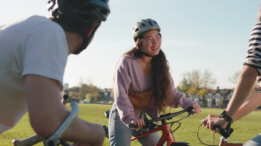 Friends cycling in a park talking