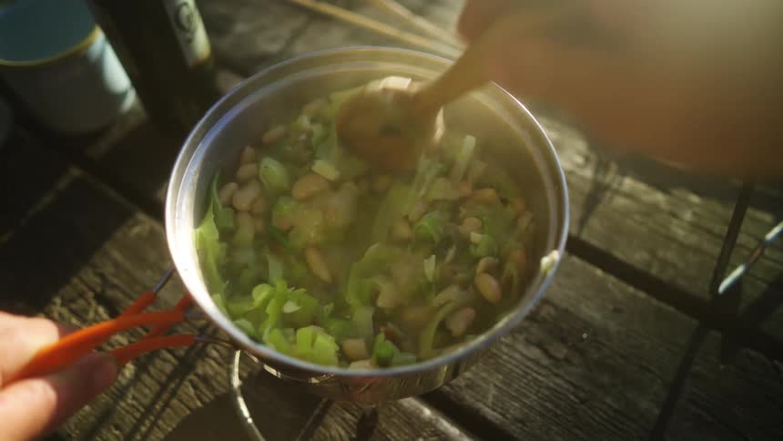 A person stirs food in a pot