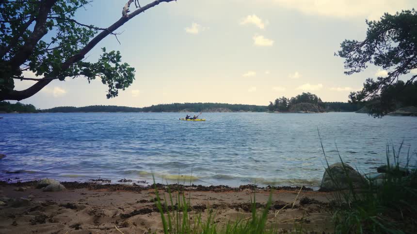 A tranquil lake scene with a kayaker in the distance