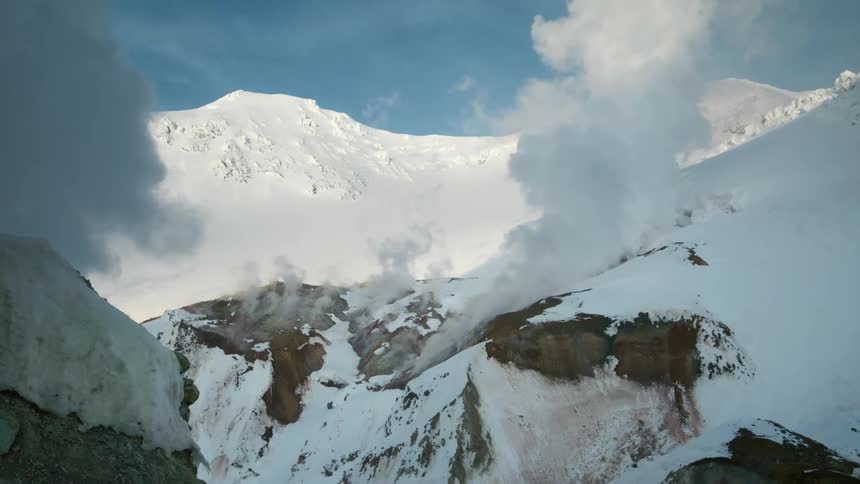 Smoke rising from snowcapped mountains