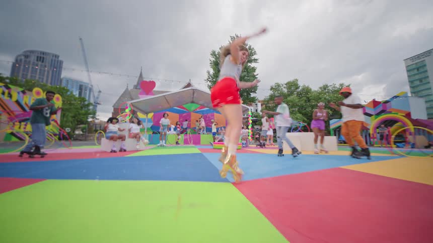 Woman with golden roller skates in motion jumping and other diverse people around on a colorful playground