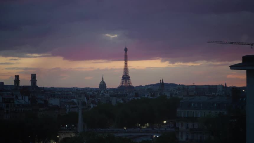 Panorama of a metropolis with the eiffel tower in the background against a dark purple sky