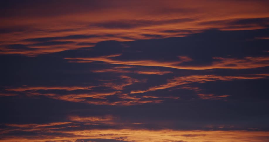 Red tints a heavily clouded sky