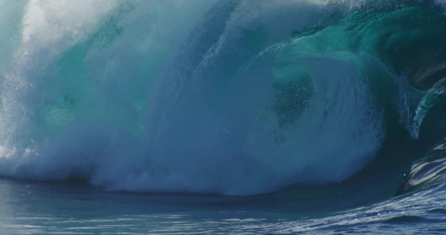 A giant wave explodes into foam as it crests and falls
