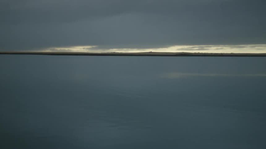 Seascape with land on the horizon on a cloudy day