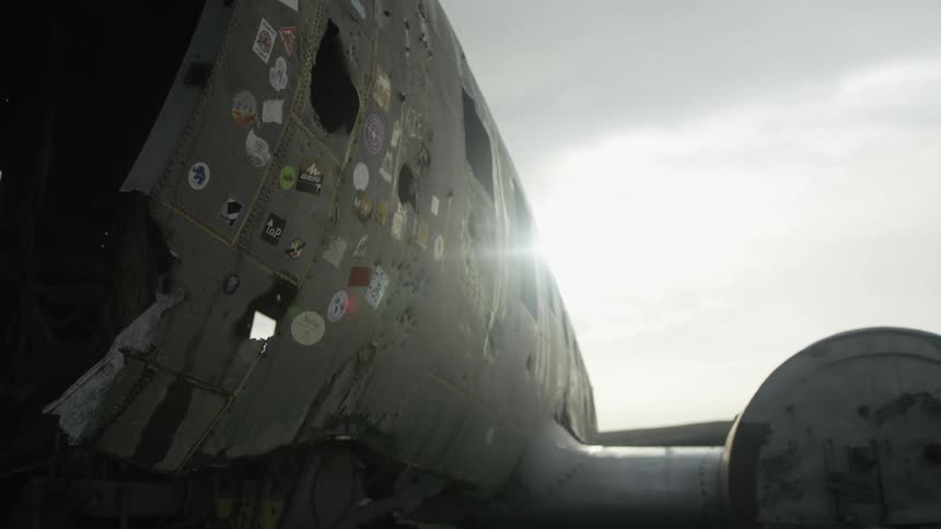Abandoned plane with its rusty metal frame and stickers stuck on it