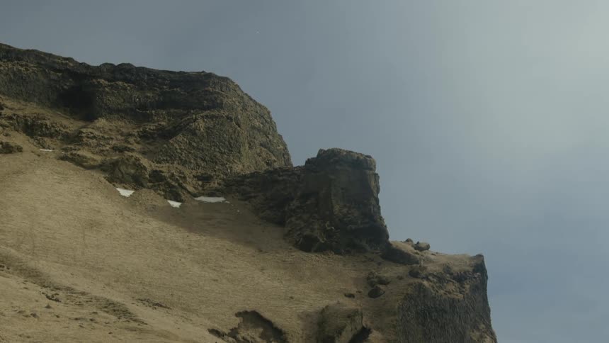 Spots of snow on small flat area on a mountain peak