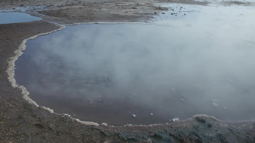 Steam rises from the small pond