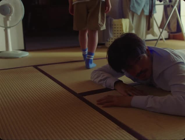 Legs of a child in front of a man and walking towards a room and the man waking up