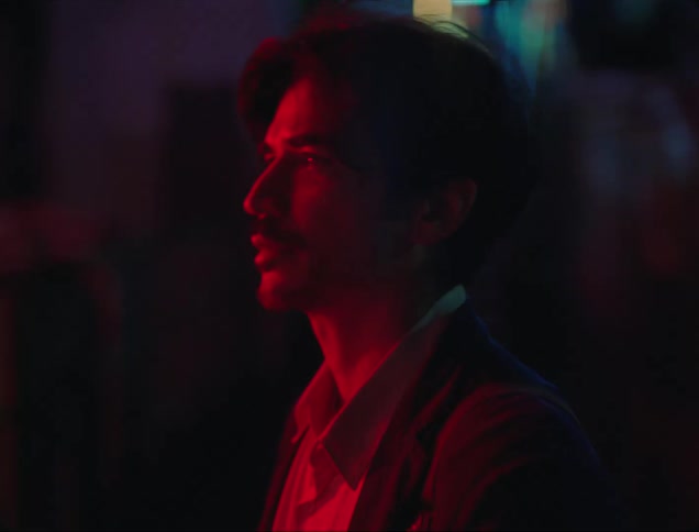 Side portrait of a man in a dark environment with red lights