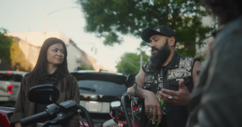 A man and a woman have a conversation and a laugh in a city street
