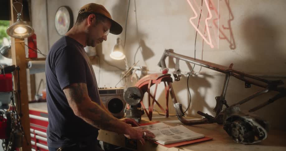 Man standing in the garage consults a book