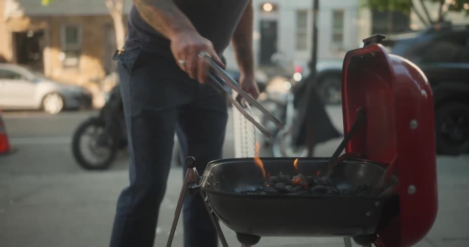 A man with a grill making a barbecue on a city street