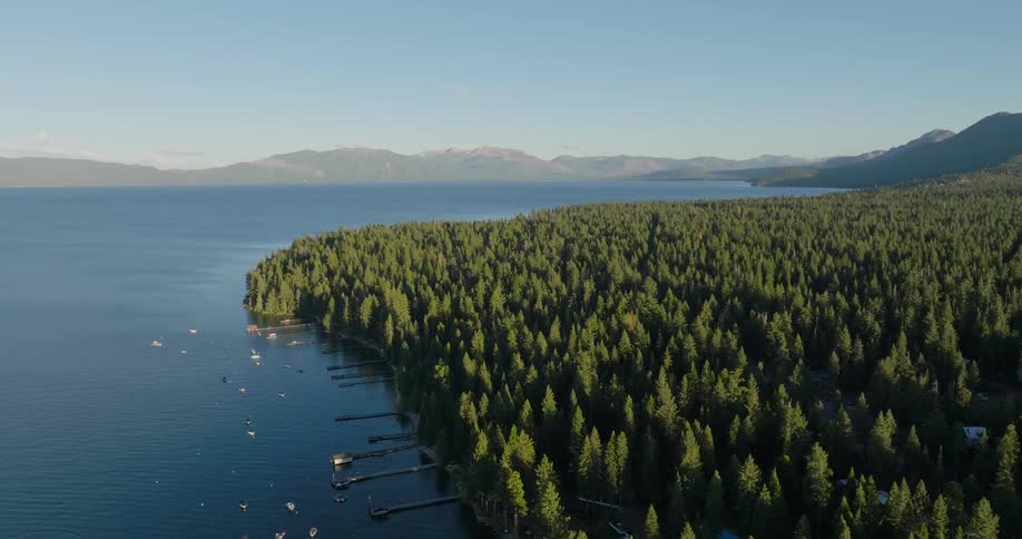 Aerial of boats anchored near the shore on a mountain lake