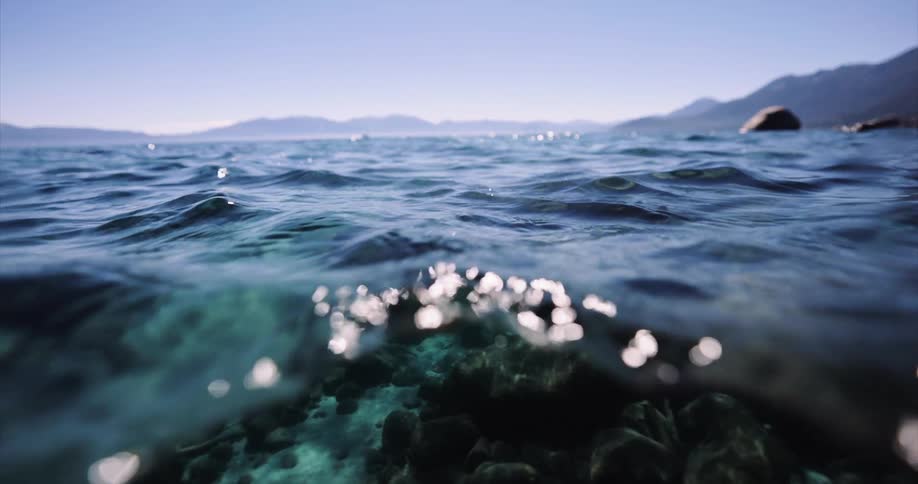 Water flows over rocks in a clear mountain lake