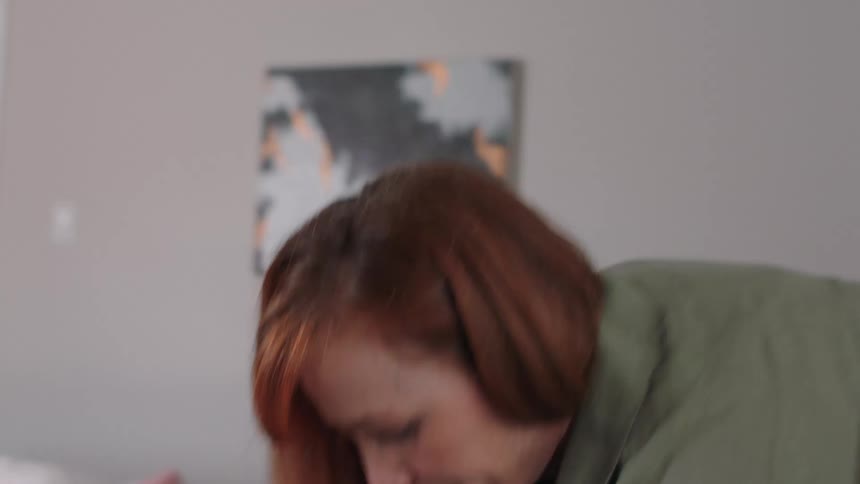 Woman writing on a sheet of paper and taking her backpack and putting books inside